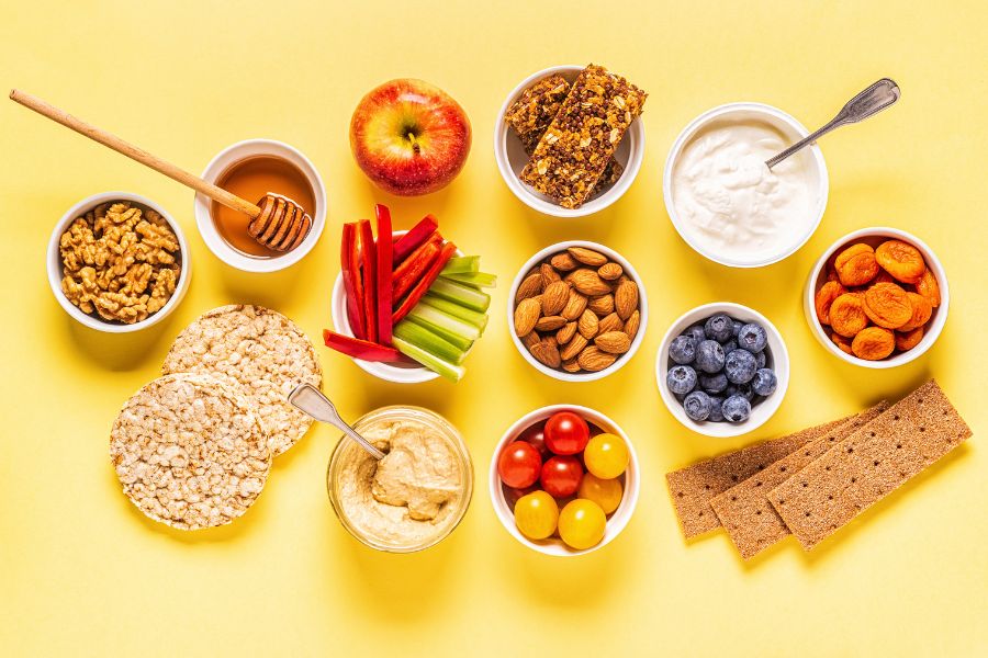 light snacks such as rice cakes, an apple, granola bars, cottage cheese, dried apricots, graham crackers, tomatoes, walnuts, almonds, cut up pepper and celery and honey